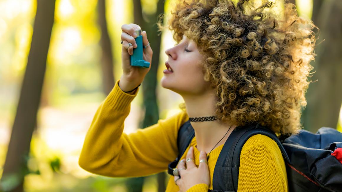 Dziewczyna z kręconymi włosami trzyma inhalator