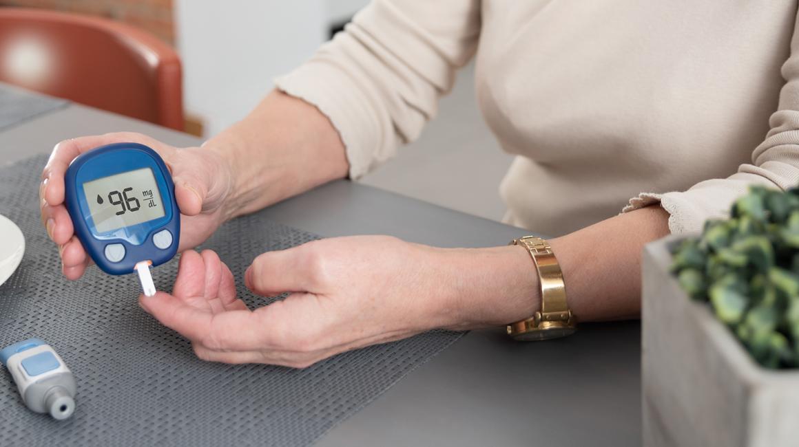 Kobieta sprawdza swój poziom cukru glukometrem