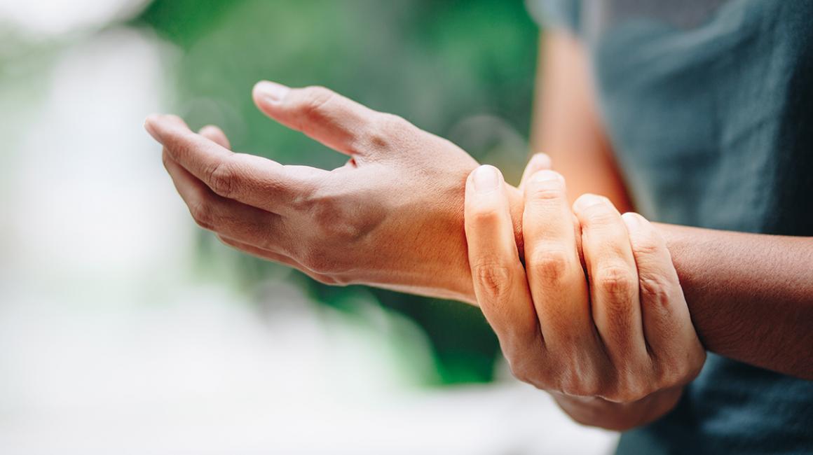 Kobieta trzyma się za nadgarstek