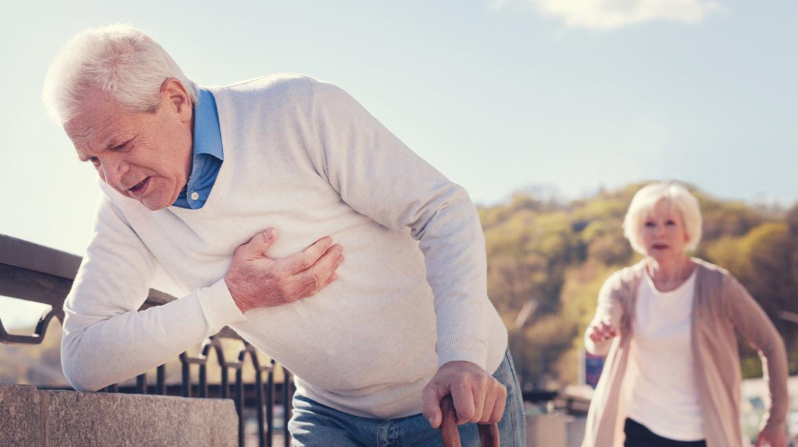 starszy pan trzyma się za serce, żona biegnie na ratunek