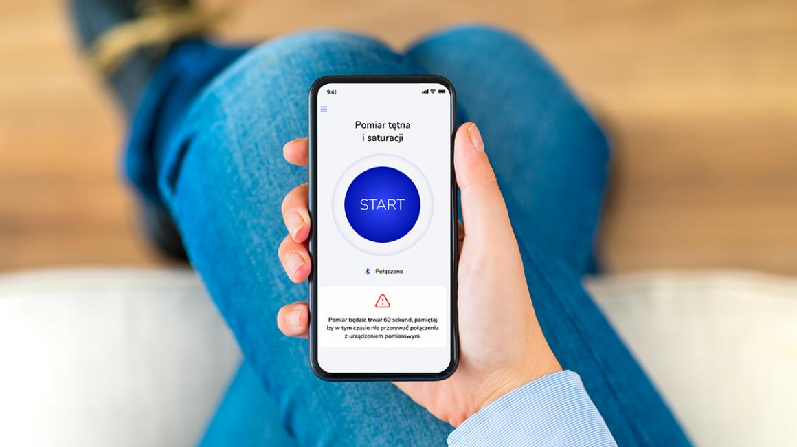 Aplikacja PulsoCare na komórce, którą ktoś trzyma