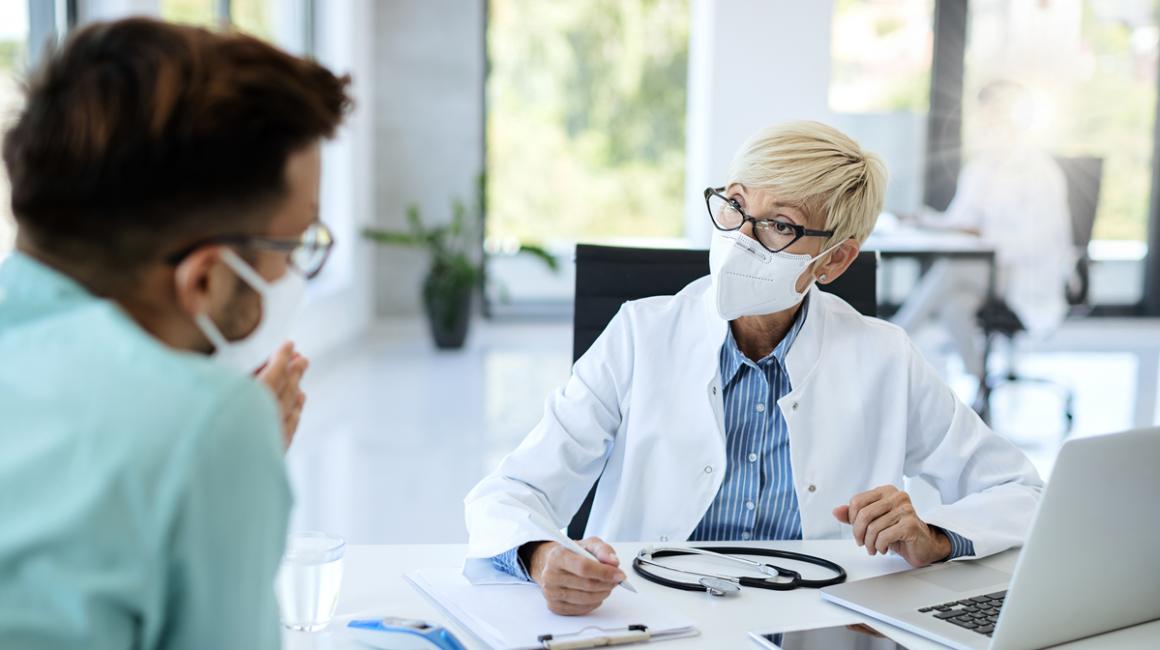 Lekarz w maseczce rozmawia z pacjentem
