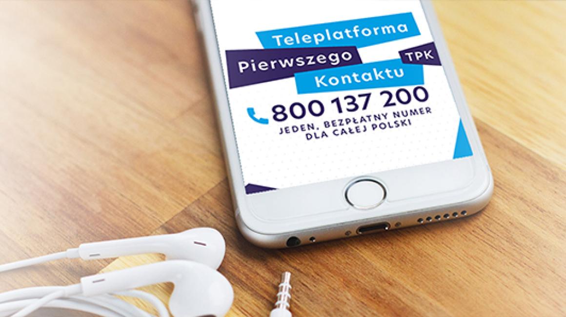 Leżący na stole telefon z widocznymi na ekranie numerem Teleplatformy Pierwszego Kontaktu