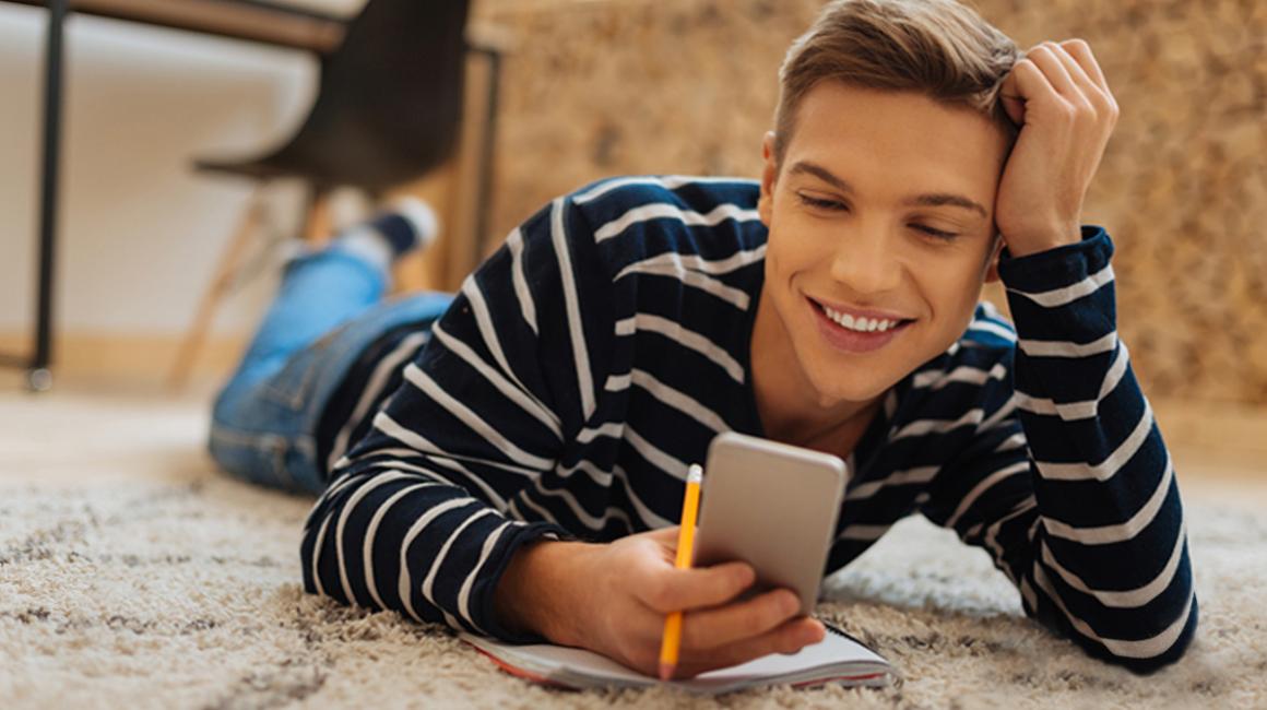 Młody mężczyzna patrzy na komórkę