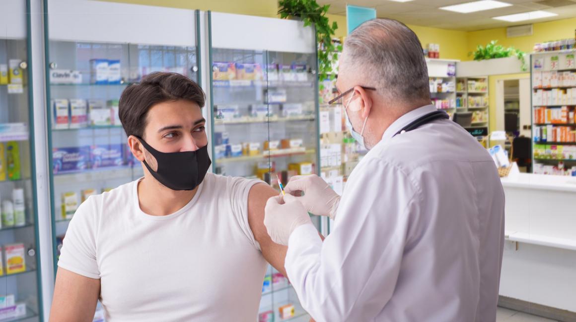 młody mężczyzna jest szczepiony przez farmaceutę