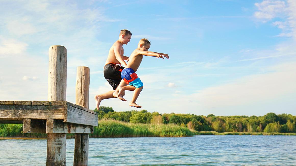 Dzieci skaczące z pomostu do wody