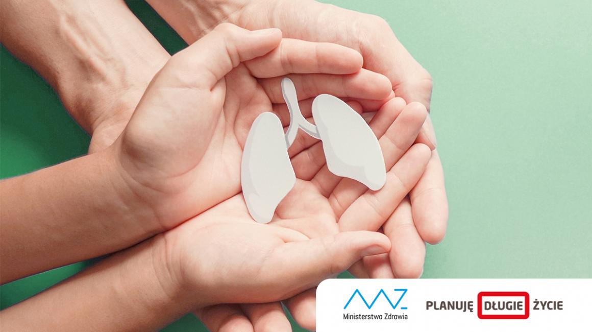 Model płuc trzymany w dłoniach, które są podtrzymywane przez większe dłonie.