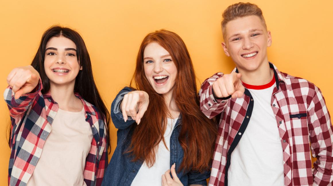 Szeroko uśmiechnięci dwie dziewczyny i chłopak w środku