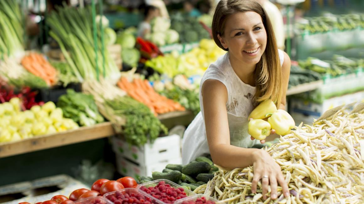Kobieta wybierająca warzywa na targu warzywnym