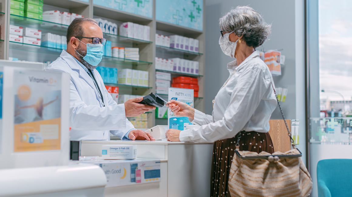 Seniorka odbiera leki w aptece