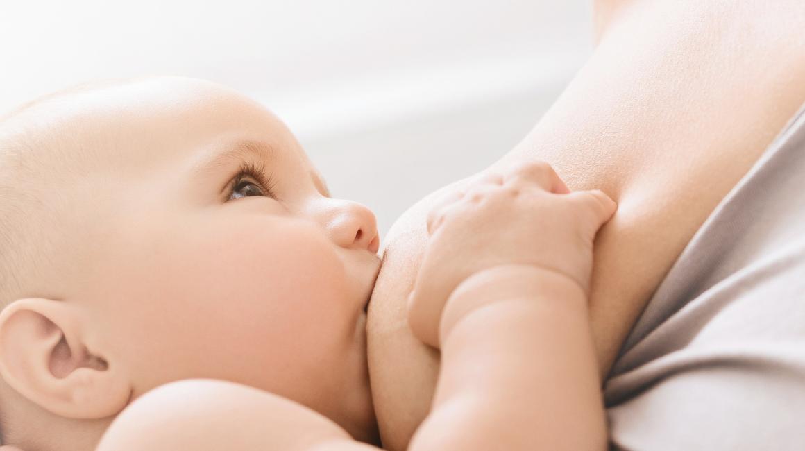 Bobas ssie mleko matki. Rączkę trzyma na jej piersi. 