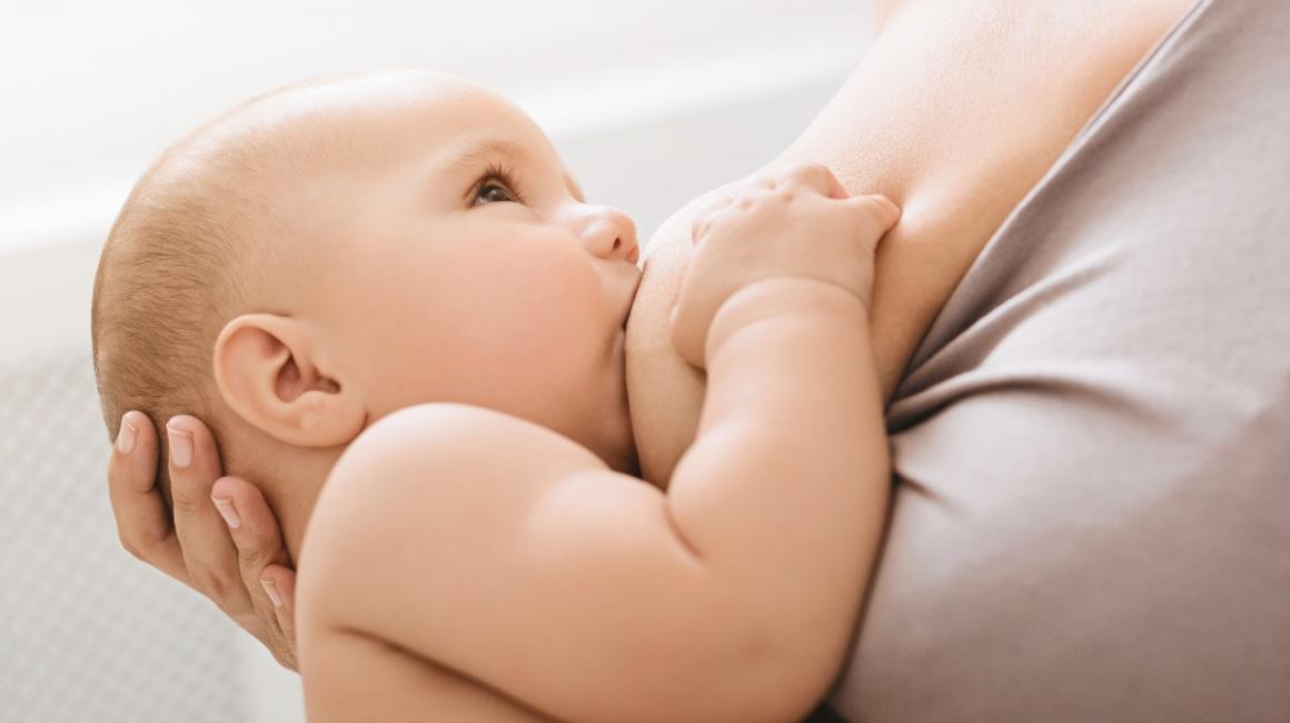Bobas ssie mleko matki. Rączkę trzyma na jej piersi. 