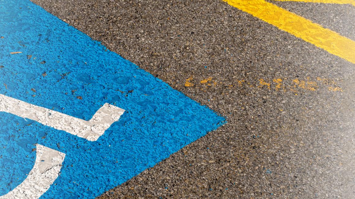 Oznaczenie miejsca do parkowania dla osoby z niepełnosprawnościa i inwalidy - wózek na niebieskim tle