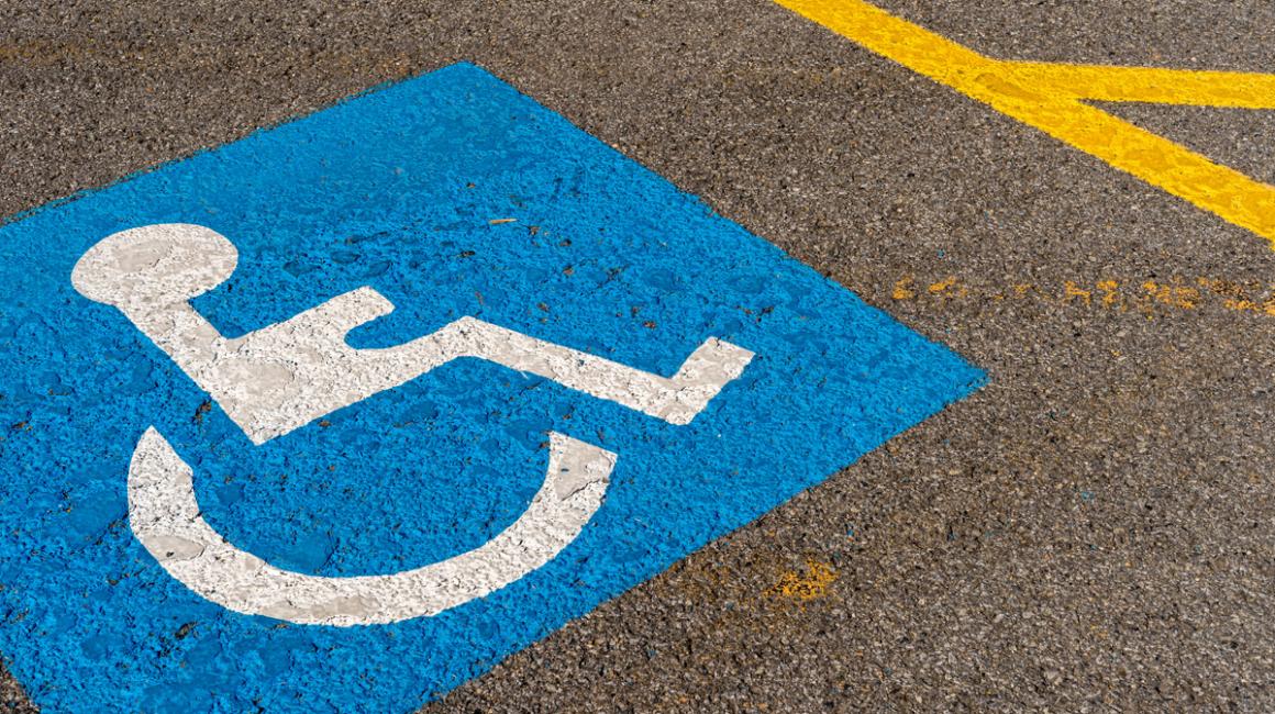 Oznaczenie miejsca do parkowania dla osoby z niepełnosprawnościa i inwalidy - wózek na niebieskim tle