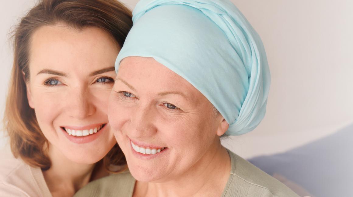 Młodsza kobieta obejmuje starszą, które głowa jest owinięta chustą