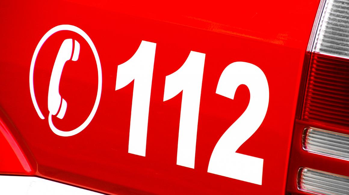 fragment czerwonego pojazu z numerem  112 i słuchawką 