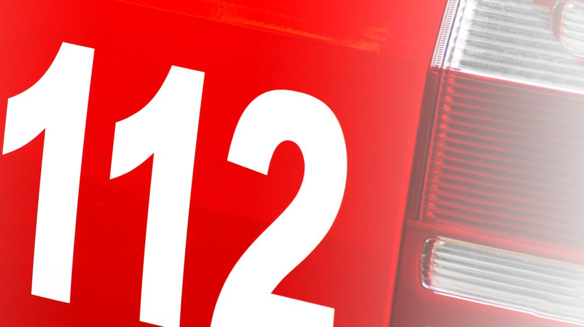 fragment czerwonego pojazu z numerem  112 i słuchawką 