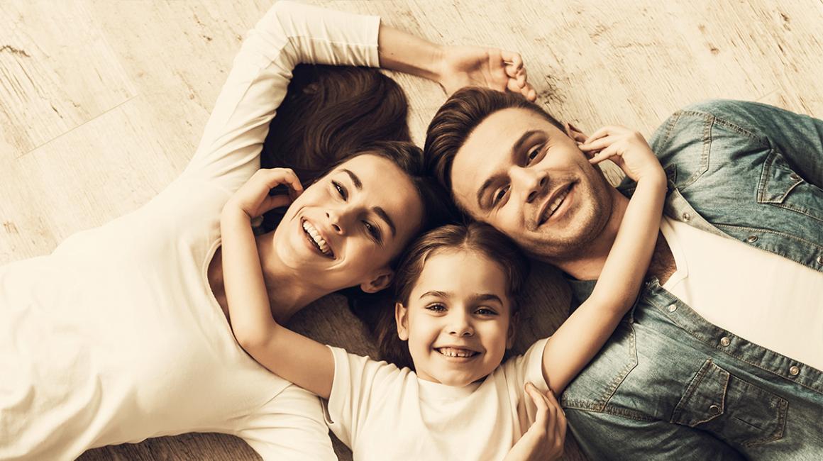 :eża rodzice i dziecko w środku. Dziecko obejmuje rodziców za szyję. Zdjecie tylko na głowy i ramiona, zrobione z rzutu ptaka