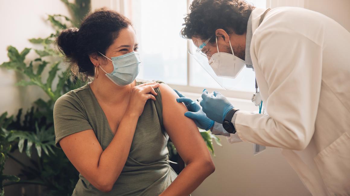 szczepienie młodej kobiety przez brodatego pielęgniarza