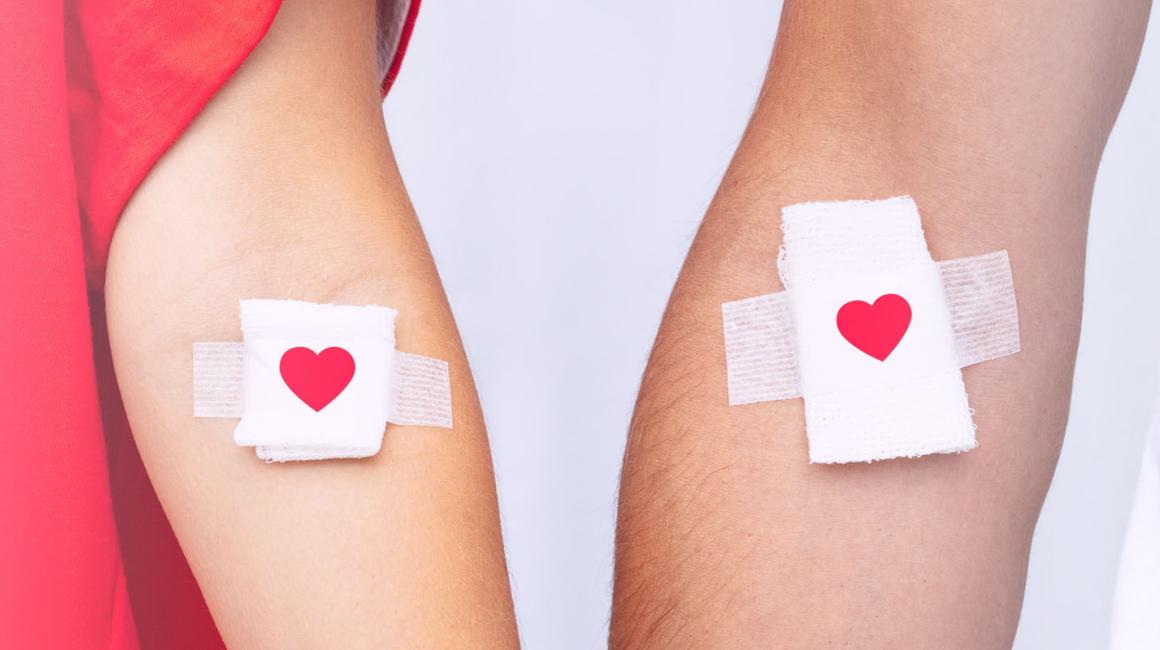 Dawcy krwi z plasterkami z czerwonymi serduszkami w miejscach wkłucia.