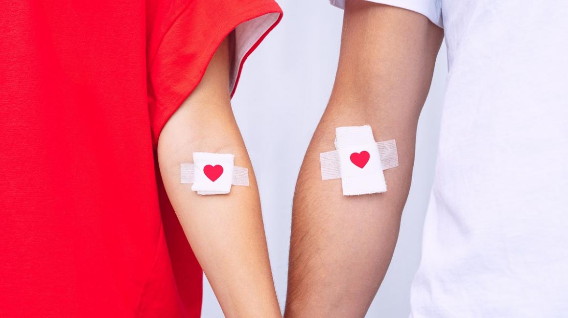 Dawcy krwi z plasterkami z czerwonymi serduszkami w miejscach wkłucia.