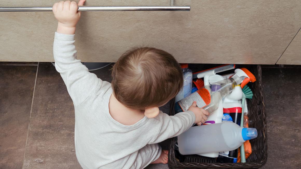 Bobas w łazience bawi się detergentami w koszyku. 