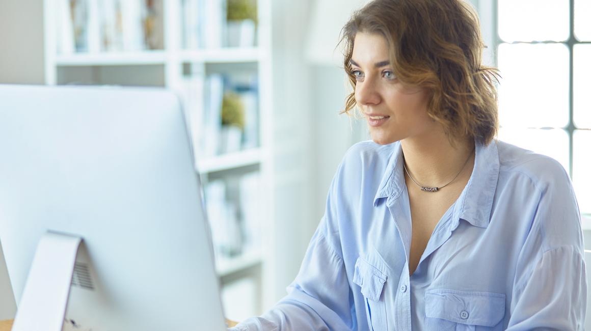 uśmiechnięta dziewczyna przed kompem