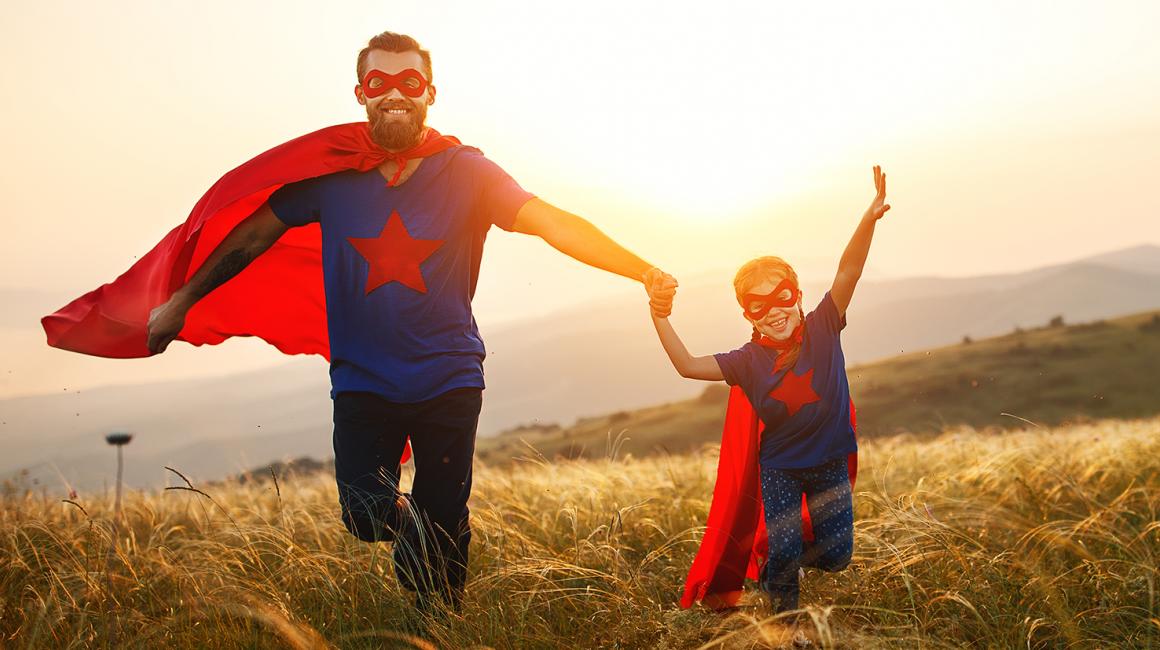 ojciec i syn na łące w czerwonych pelerynach