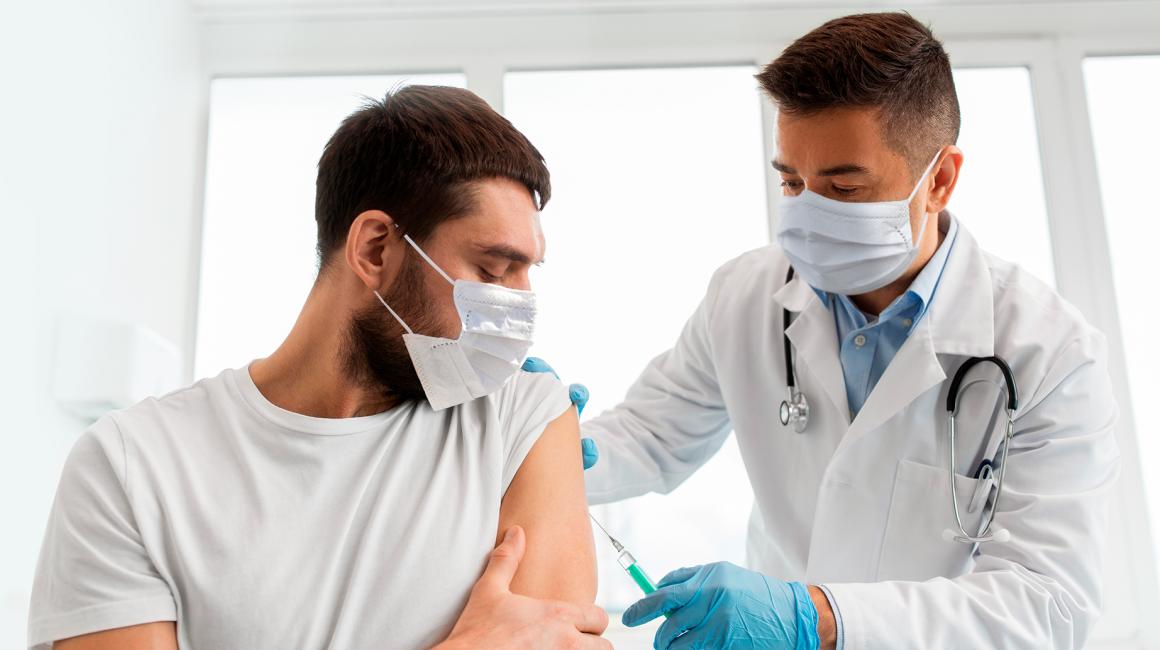 Pielęgniarz robi zastrzyk w ramię mężczyzny