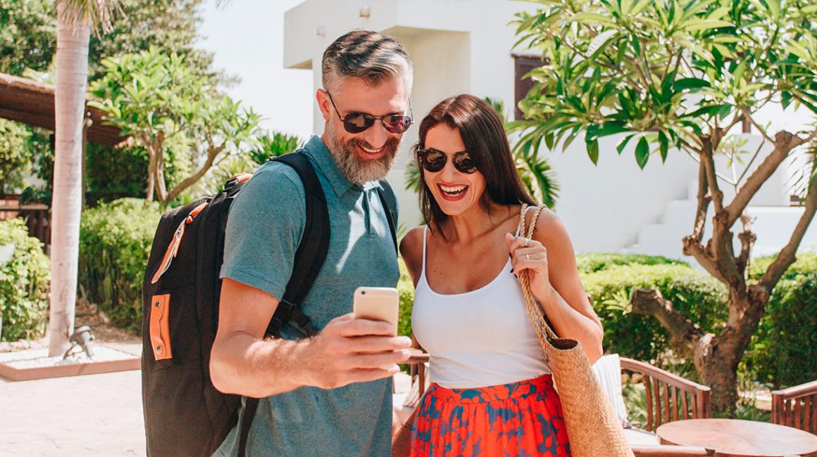 małzeństwo na urlopie patrzy na komórkę