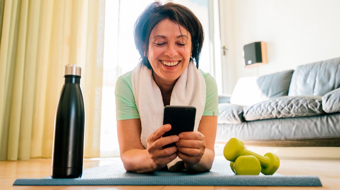 kobieta na macie patrzy na komórkę