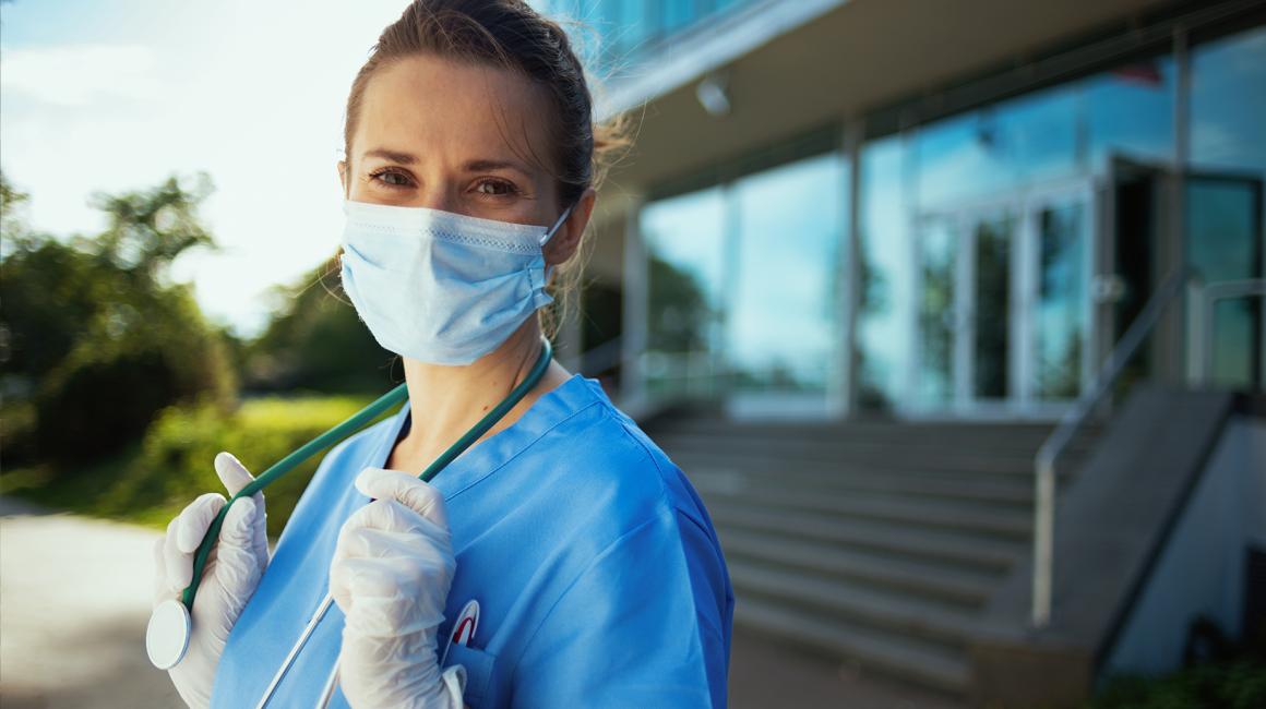 kobieta w maseczce, niebieskim kitlu i ze stetoskopem