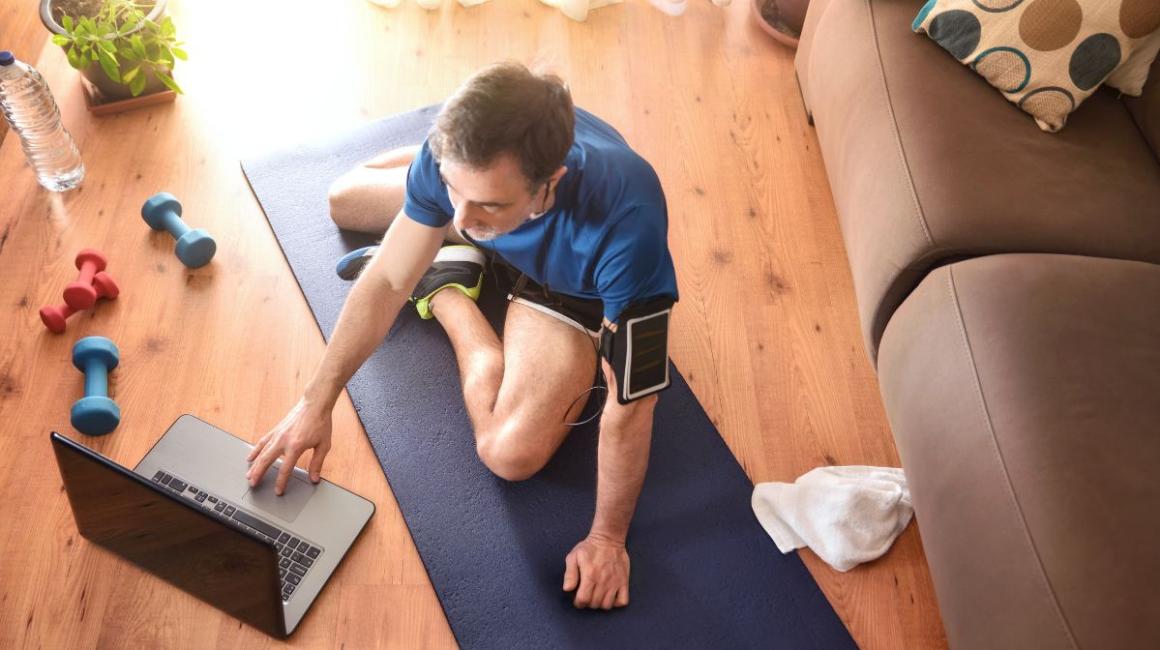 mężczyzna siedzi na podłodsze z laptopem