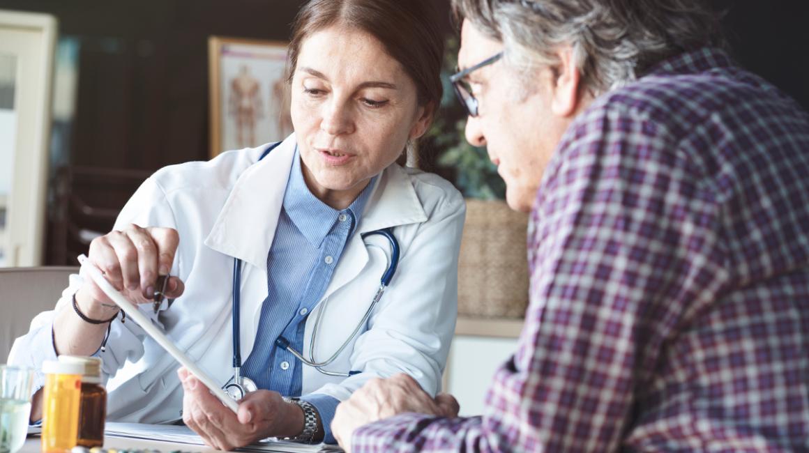 Lekarka omawia wyniki badań z pacjentem, który jest mężczyzna w 50 roku życia.