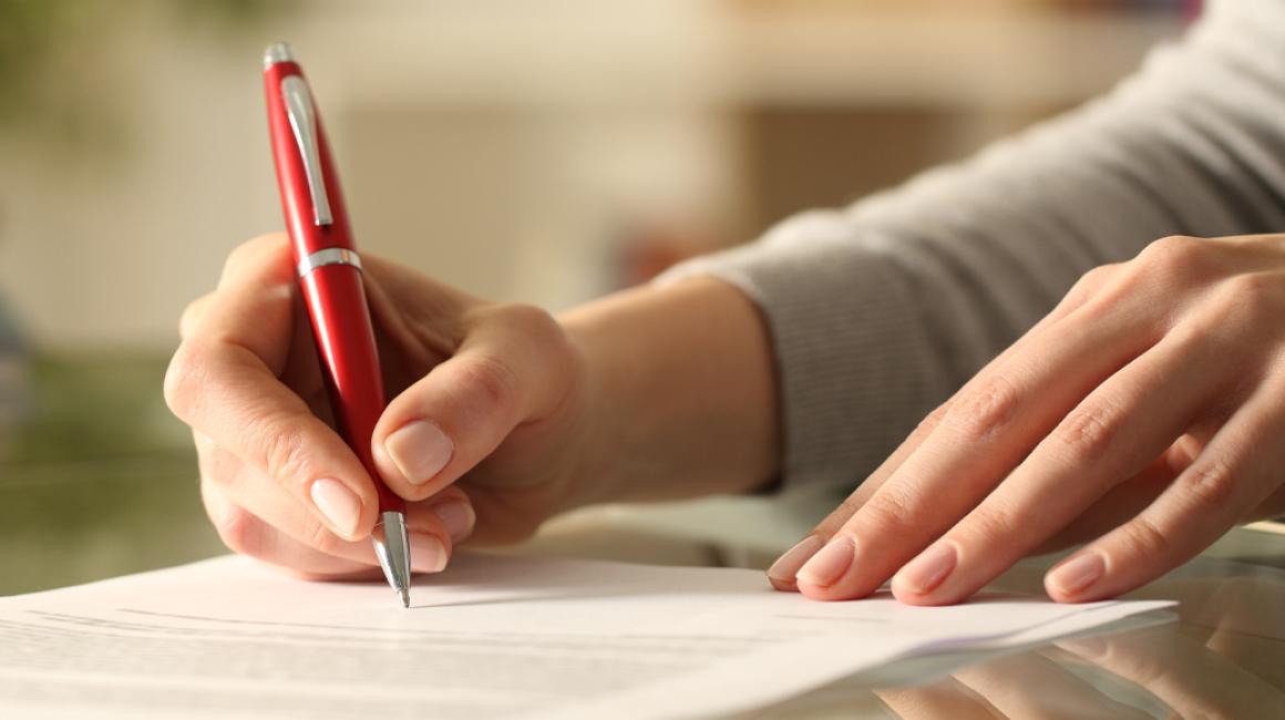 Damskie dłonie wypełniają formularz.
