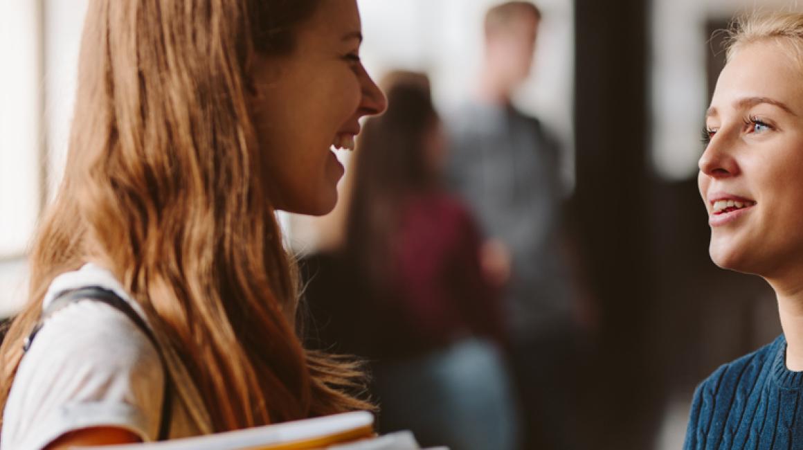 Dwie studentki rozmawiają na korytarzu.