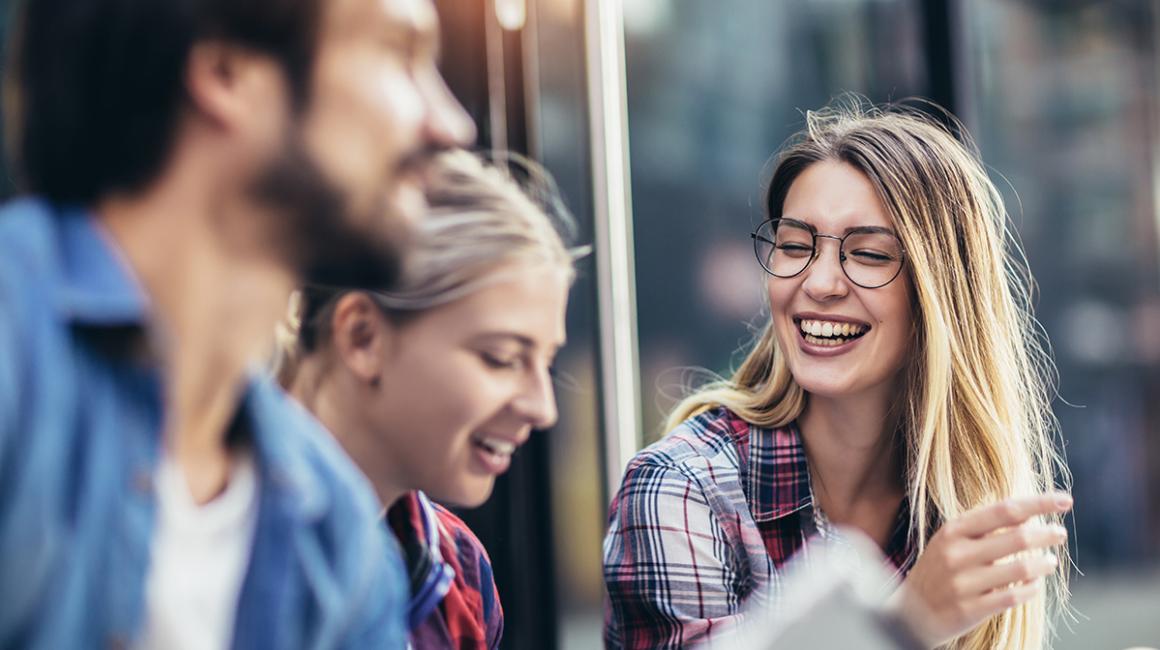 Trzy młode, roześmiane osoby. Widoczne tylko twarze.