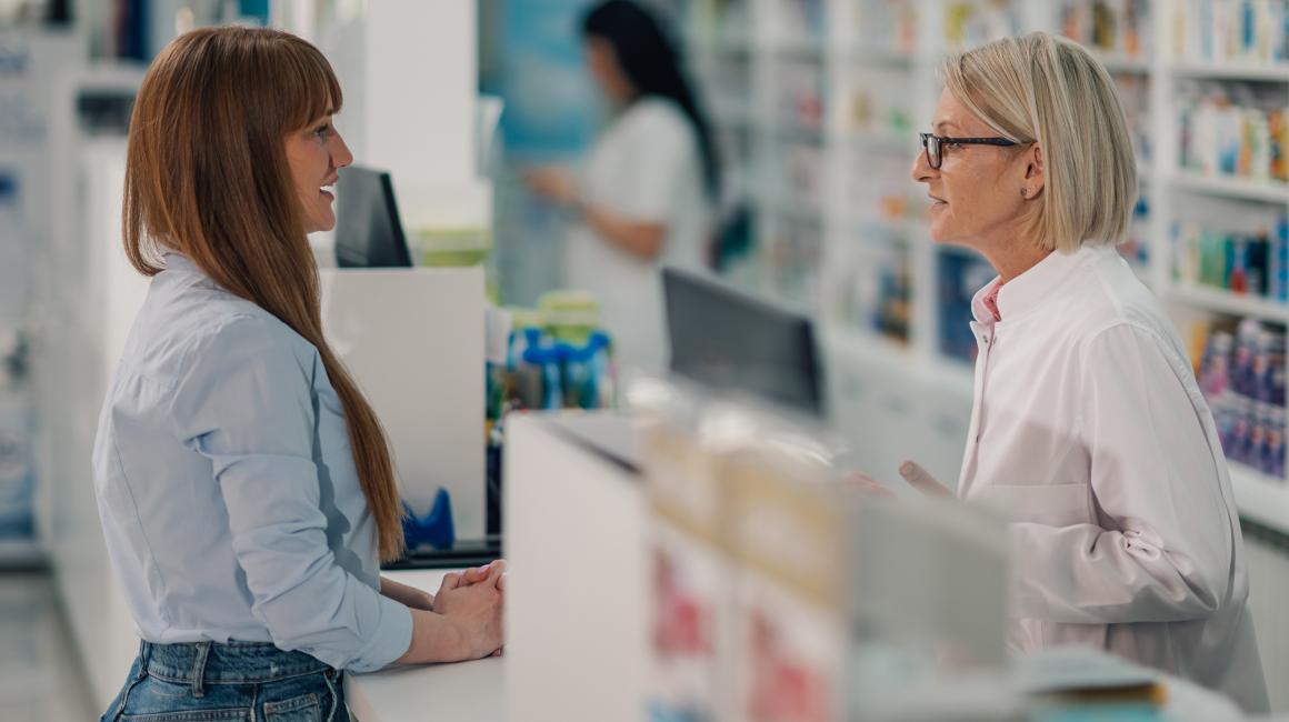 Kobieta rozmawia w aptece z farmaceutka