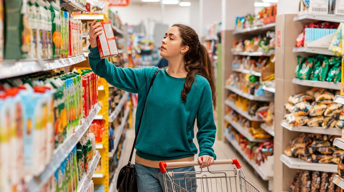 kobieta w sklepie czyta opakowanie produktu