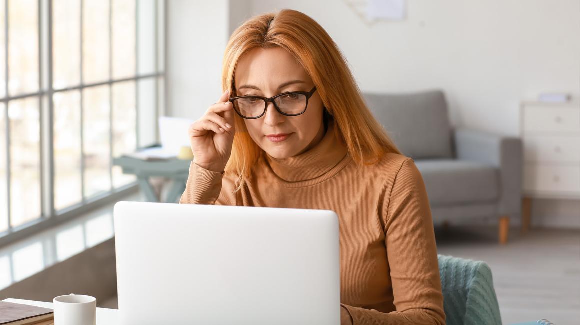 Kobieta w beżowym golfie przed komputerem