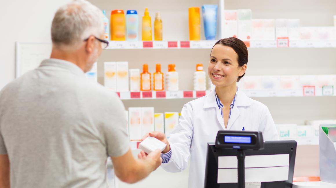 Farmaceutka bez maseczki wydaje starszemu panu lek