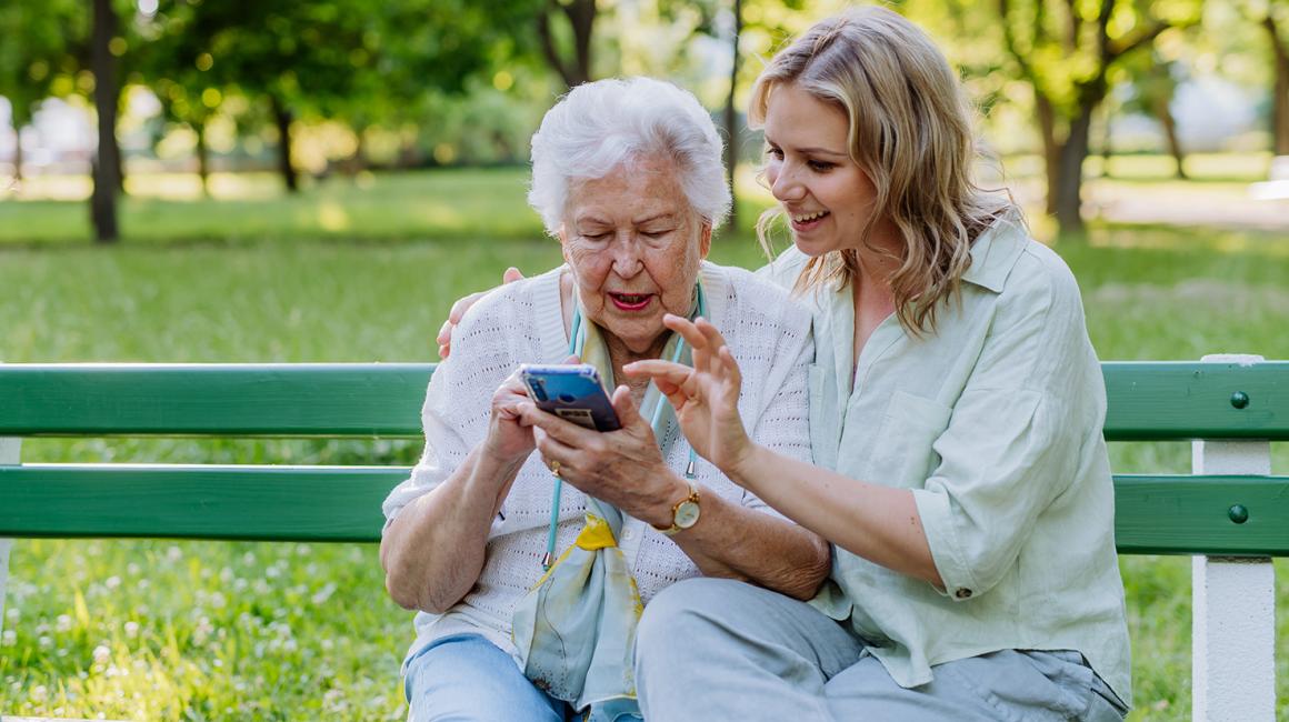 Mloda dziewczyna pokazuje seniorce coś na komórce