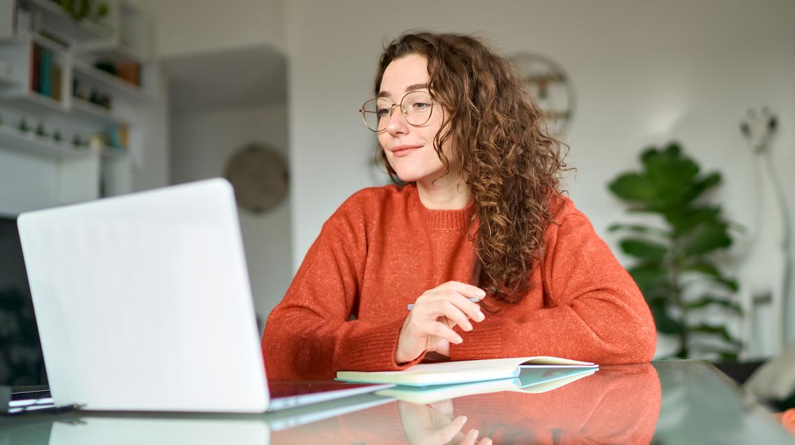 dziewczyna z długimi kręconymi włosami przed laptopem