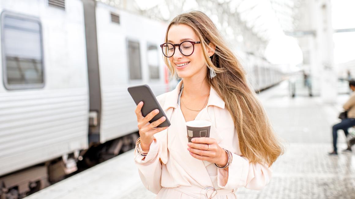 dziewczyna z długimi włosami na peronie z komórką w ręku