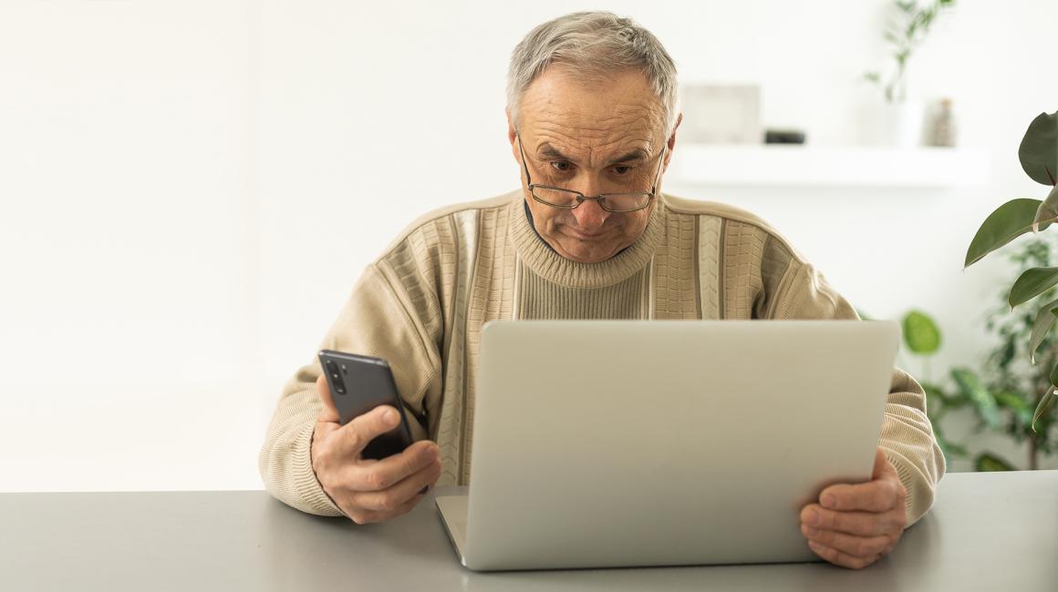 Mężczyzna z laptopem i komórką