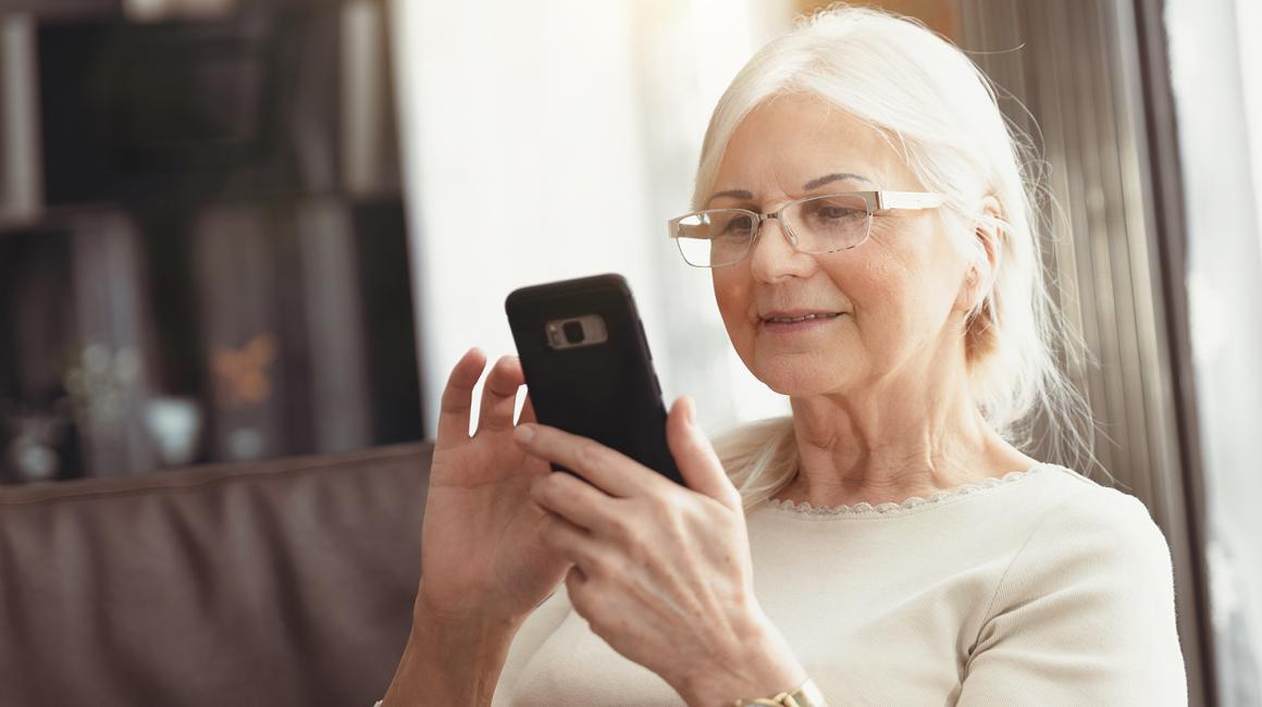 siwa pani z uśmiechem patrzy na telefon