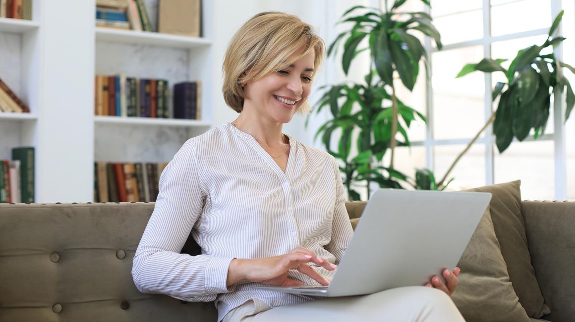 pani na kanapie z laptopem, w białej koszuli,