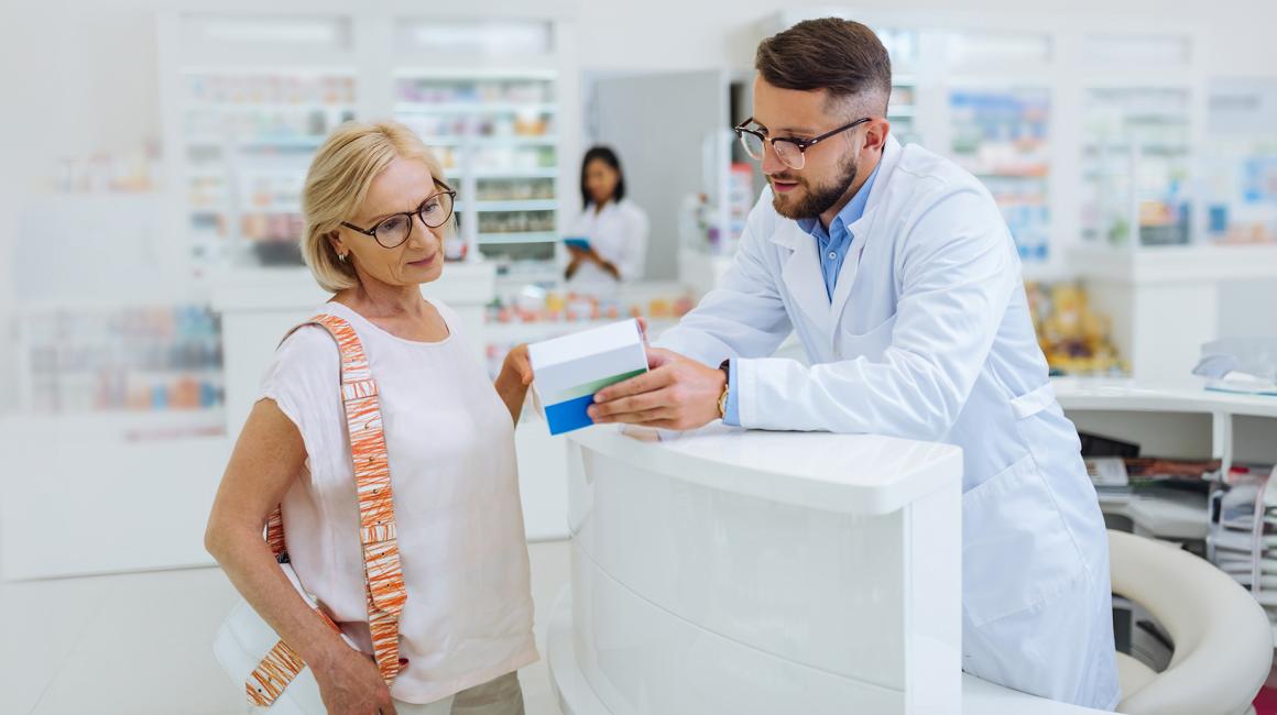 farmaceuta tlumaczy coś klientce, pani w srednim wieku w t-shircie