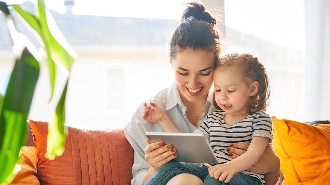 Mama z 2letnim dzieckiem na kanapie, trzyma tablet