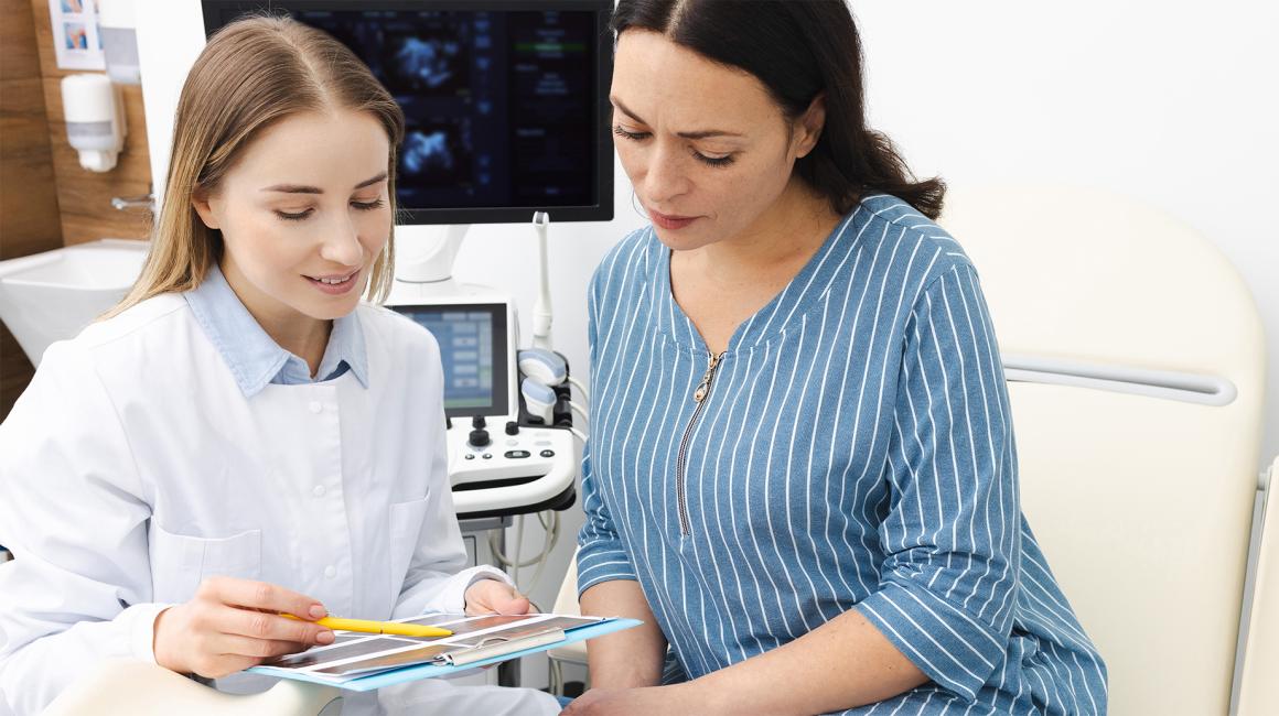 Pacjentka rozmawia z lekarką, która pokazuje jej wyniki